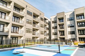 Apartment building with a pool in front.